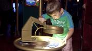 A child investigating an object through a giant magnifying glass
